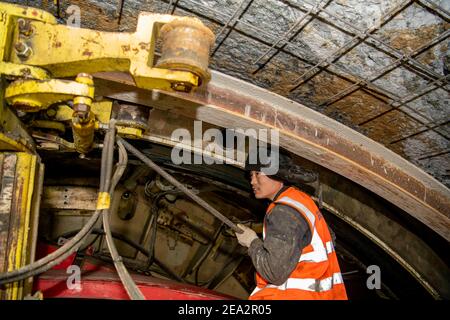 (210207) -- URUMQI, 7. Februar 2021 (Xinhua) -- EIN Arbeiter ist auf der Baustelle des Tianshan Shengli Tunnels in der Autonomen Region Xinjiang Uygur im Nordwesten Chinas beschäftigt, 5. Februar 2021. Der Tianshan Shengli-Tunnel ist mit einer Gesamtlänge von rund 22 Kilometern derzeit der längste im Bau befindliche Autobahntunnel in China. Der 2020 begonnene Tunnel, ein sechsjähriges Projekt auf der Urumqi-Yuli-Autobahn, durchläuft eine kalte und hochgelegene Zone mit rauem Klima und geologischem Zustand. Nach der Fertigstellung und für den Verkehr geöffnet, wird es sicherer und bequemer Reisen für die Passagiere und p Stockfoto