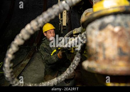 (210207) -- URUMQI, 7. Februar 2021 (Xinhua) -- EIN Arbeiter ist auf der Baustelle des Tianshan Shengli Tunnels in der Autonomen Region Xinjiang Uygur im Nordwesten Chinas beschäftigt, 4. Februar 2021. Der Tianshan Shengli-Tunnel ist mit einer Gesamtlänge von rund 22 Kilometern derzeit der längste im Bau befindliche Autobahntunnel in China. Der 2020 begonnene Tunnel, ein sechsjähriges Projekt auf der Urumqi-Yuli-Autobahn, durchläuft eine kalte und hochgelegene Zone mit rauem Klima und geologischem Zustand. Nach der Fertigstellung und für den Verkehr geöffnet, wird es sicherer und bequemer Reisen für die Passagiere und p Stockfoto