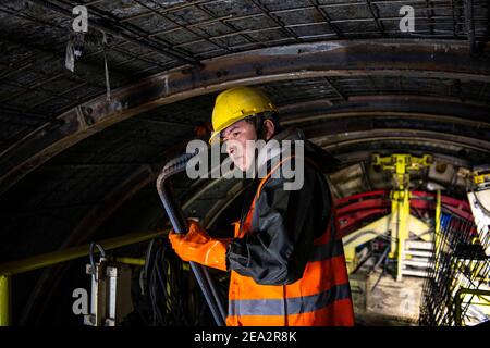 (210207) -- URUMQI, 7. Februar 2021 (Xinhua) -- EIN Arbeiter wird auf der Baustelle des Tianshan Shengli Tunnels in der Autonomen Region Xinjiang Uygur im Nordwesten Chinas, 4. Februar 2021, gesehen. Der Tianshan Shengli-Tunnel ist mit einer Gesamtlänge von rund 22 Kilometern derzeit der längste im Bau befindliche Autobahntunnel in China. Der 2020 begonnene Tunnel, ein sechsjähriges Projekt auf der Urumqi-Yuli-Autobahn, durchläuft eine kalte und hochgelegene Zone mit rauem Klima und geologischem Zustand. Nach der Fertigstellung und für den Verkehr geöffnet, wird es sicherer und bequemer Reisen für die Passagiere und p Stockfoto