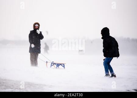 Berlin, Deutschland. Februar 2021, 07th. Deutschland, Berlin, 07. Februar 2021: Zwei Menschen genießen den frischen Schnee im Tempelhofer Feld. Der Deutsche Wetterdienst warnt vor heftigem Schneefall mit Windwirbeleien bei Temperaturen, die deutlich unter dem Gefrierpunkt liegen. (Foto: Jan Scheunert/Sipa USA) Quelle: SIPA USA/Alamy Live News Stockfoto