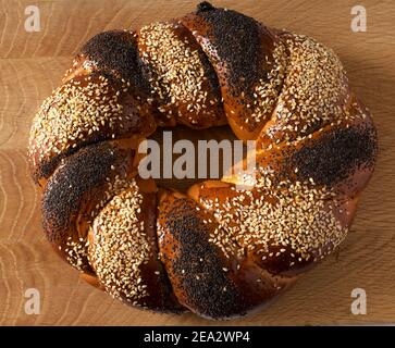 Ein süßes slawisches Brötchen, das in Form eines Ringes namens Kalach auf einem Holzbrett hergestellt wurde Stockfoto