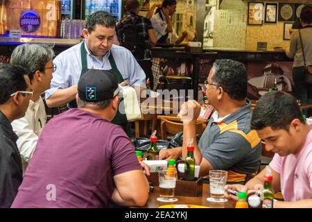 Ein Kellner nimmt eine Bestellung bei einem der kleinen an Cafés auf dem 2nd-stöckigen Food Court in der historischen Öffentlichkeit Unter überdachten städtischen Markt (Mercado Stockfoto