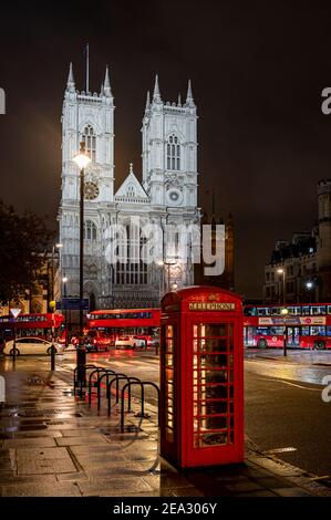 Westminster Abbey bei Nacht mit rotem Telefonkasten und Londoner Bussen, London Stockfoto