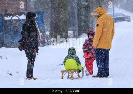 Haltern, NRW, Deutschland. Februar 2021, 07th. Eine Familie nimmt ihre Kinder auf Schlitten für einen Spaziergang durch das Dorf. Die Menschen im Dorf Sythen bei Haltern machen das Beste aus dem rund 30 cm großen Neuschnee. Für Teile Nordrhein-Westfalens und andere Gebiete gibt es eine Unwetterwarnung, nachdem Schneestürme Verkehrschaos und Probleme mit dem öffentlichen Verkehr gebracht haben. Es wird weiterhin schneien, mit Temperaturen weit unter Null für die nächsten Tage. Kredit: Imageplotter/Alamy Live Nachrichten Stockfoto