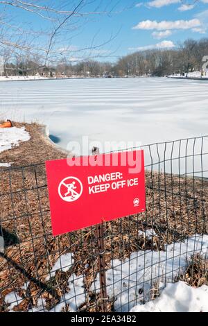 Ein Schild im kissena Park warnt die Menschen davor, auf das Eis zu gehen, wenn der See friert. In Flushing, Queens, New York City. Stockfoto