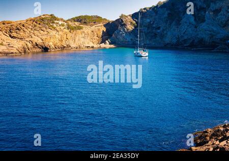 Blick auf Punta des Plon in der Bucht von Sa Tuna, wo ein Segelboot vor Anker liegt. Begur, Costa Brava, Katalonien, Spanien Stockfoto