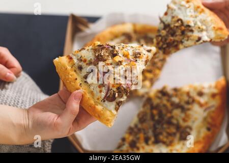 Junges Paar, das Pizza isst. Draufsicht Hände mit Pizza Stockfoto