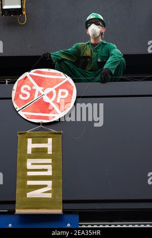 Ein männlicher Aktivist, der ein Plakat hält, klettert auf das Dach der Euston Station, London, Großbritannien, aus Protest gegen das Projekt HS2, 29th. Januar 2021. Stockfoto