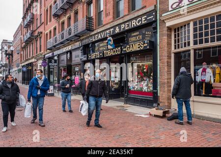 In Cambridge, in der Nähe der Harvard University, laufen die Käufer in Masken und Einkaufstaschen entlang einer belebten Straße. Stockfoto