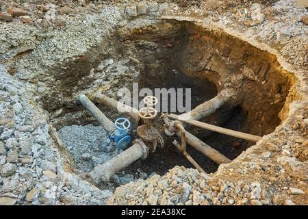 Alte Stadt Wasser Haupthähne, ein Loch gegraben, um zu reparieren oder ersetzen Wasserversorgungseinheiten Stockfoto