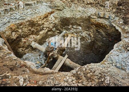 Alte Stadt Wasser Haupthähne, ein Loch gegraben, um zu reparieren oder ersetzen Wasserversorgungseinheiten Stockfoto