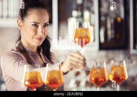 Barkeeper prüft die Qualität eines orangen aperol Spritz im Glas. Stockfoto