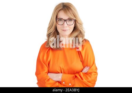Porträtaufnahme einer lächelnden Geschäftsfrau, die mit gekreuzten Armen auf einem isolierten weißen Hintergrund steht. Stockfoto
