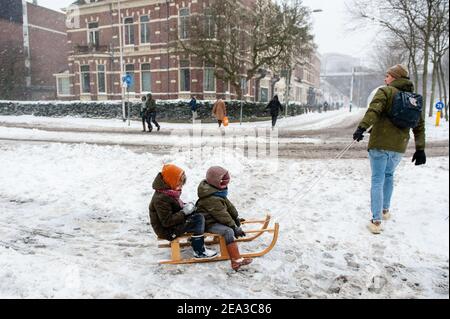 Ein Mann wird gesehen, wie er mit seinen Kindern einen Schlitten zieht. Die Niederlande erwachten mit einer Schneeschicht, die den größten Teil des Landes bedeckte. Das meteorologische Institut KNMI hat einen Code Red Weather alert für das ganze Land herausgegeben. Gruppen von Menschen und Familien waren im Schnee im Kronenburg Park in Nijmegen Schlittenfahren. Im östlichen Teil von Gelderland und um Nijmegen wird der Schneespiegel auf rund 25 Zentimeter ansteigen, bevor der Schnee aufhört. Stockfoto