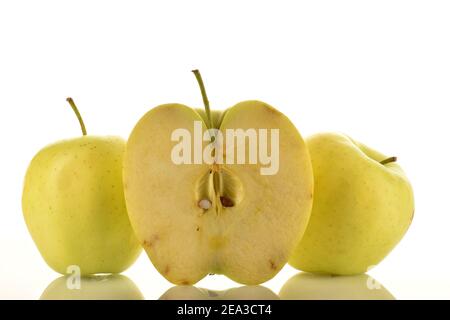 Eine Hälfte und zwei ganze saftige gelbe Äpfel, Nahaufnahme, auf weißem Hintergrund. Stockfoto