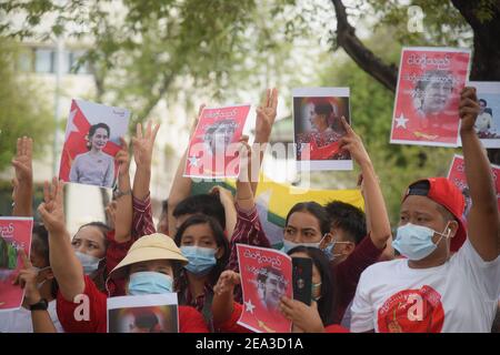 Demonstranten mit Porträts der inhaftierten Zivilführerin Aung San Suu Kyi während der Demonstration gegen den Militärputsch Bürger von Myanmar protestieren vor dem UN-Veranstaltungsort in Bangkok gegen den Militärputsch in Myanmar. Stockfoto