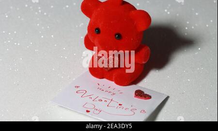 Roter Bär mit glänzendem Herz mit Valentinstag Umschlag als Geschenk oder Geschenk an Valentinstag oder Frauen Geburtstag. Stockfoto