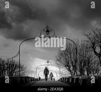 Schwarz-Weiß-Foto von Menschen, die auf der Pont Vieux (die alte Brücke) in Carcassonne, Südfrankreich, über den Fluss Aude wandern. Stockfoto