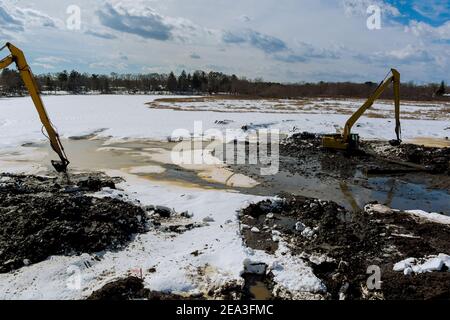 Bagger baggern und säubern einen See den Winterschnee Des Seegrunds Stockfoto