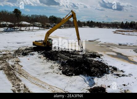 Reinigung der Boden des Sees mit einem Bagger Bagger Bagger Im Winterschnee Stockfoto