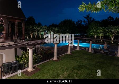 Außenterrasse mit Blick auf den Swimmingpool in der Nacht. Stockfoto