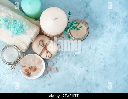 Handtücher, Kerzen und Reinigungsmittel auf Cyanid-Hintergrund. Stockfoto