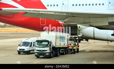 London, England - Juli 2018: Luftfracht wird in den hinteren Frachtraum eines Qantas Airbus A380 verladen. Stockfoto