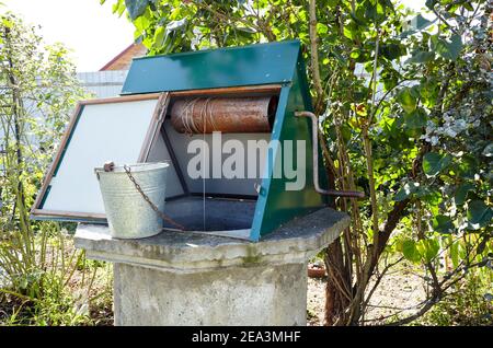 Alte Ziehbrunnen im europäischen Dorf. Retro Steinwasserbrunnen in ländlicher Umgebung Stockfoto