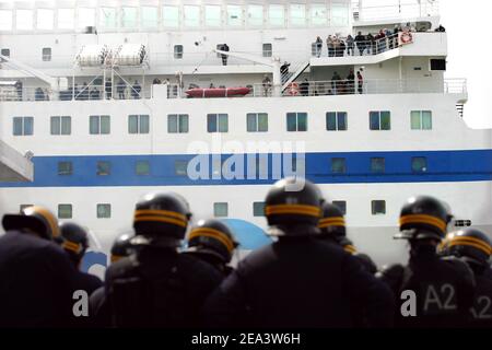 Französische Seeleute der Reederei SNCM (National Maritime-Corsica Mediterranean Company) streiken, besetzen die Fähre "Mediterranee" und verbrennen Autos, während Polizisten am 18. April 2005 im Hafen von Marseille, Südfrankreich, vorbeischauen. Die Demonstranten streikten gegen die Verabschiedung der Gesetzgebung zur Schaffung eines neuen Low-Cost-Registers der Französischen Internationale. Foto von Gerald Holubowicz/ABACA Stockfoto