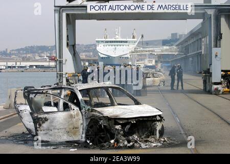 Französische Seeleute der Reederei SNCM (National Maritime-Corsica Mediterranean Company) streiken, besetzen die Fähre "Mediterranee" und verbrennen Autos, während Polizisten am 18. April 2005 im Hafen von Marseille, Südfrankreich, vorbeischauen. Die Demonstranten streikten gegen die Verabschiedung der Gesetzgebung zur Schaffung eines neuen Low-Cost-Registers der Französischen Internationale. Foto von Gerald Holubowicz/ABACA Stockfoto