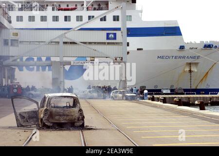 Französische Seeleute der Reederei SNCM (National Maritime-Corsica Mediterranean Company) streiken, besetzen die Fähre "Mediterranee" und verbrennen Autos, während Polizisten am 18. April 2005 im Hafen von Marseille, Südfrankreich, vorbeischauen. Die Demonstranten streikten gegen die Verabschiedung der Gesetzgebung zur Schaffung eines neuen Low-Cost-Registers der Französischen Internationale. Foto von Gerald Holubowicz/ABACA Stockfoto