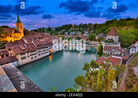 Skyline von Bern, Hauptstadt der Schweiz zur blauen Stunde, die in der Aare reflektiert wird. Panoramablick auf die Altstadt, die Nydegg-Kirche und die Untertorbrücke Stockfoto