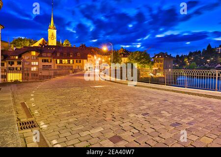 Fussgängerbrücke Untertorbrücke in der Berner Altstadt mit Blick auf die nachts beleuchtete Nydeggkirche. Hauptstadt der Schweiz, historisches Zentrum Stockfoto