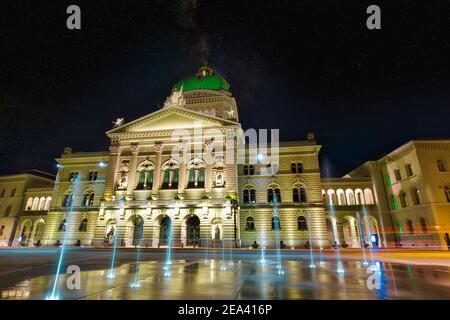 Bundespalastfassade mit Brunnen in Bern, Schweiz bei Nacht beleuchtet. Schweizerisches Parlamentsgebäude am Bundesplatz. Wahrzeichen des historischen Stockfoto
