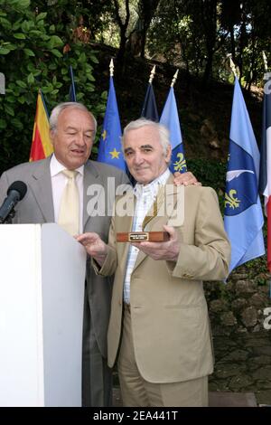 Der französische Sänger Charles Aznavour (r) erhält vom Bürgermeister von Cannes, Bernard Brochand, die Medaille des Ehrenbürgers und der Palme der Stadt während einer Zeremonie in der Villa Domergue in Cannes, Frankreich am 18. Mai 2005. Foto von Benoit Pinguet/ABACA Stockfoto