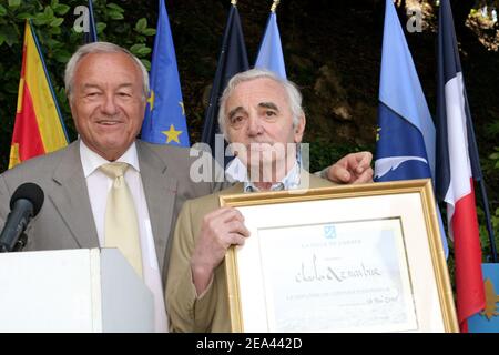 Der französische Sänger Charles Aznavour (r) erhält vom Bürgermeister von Cannes, Bernard Brochand, die Medaille des Ehrenbürgers und der Palme der Stadt während einer Zeremonie in der Villa Domergue in Cannes, Frankreich am 18. Mai 2005. Foto von Benoit Pinguet/ABACA Stockfoto