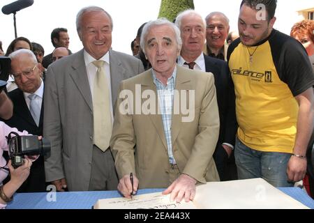 Der französische Sänger Charles Aznavour (C) erhält vom Bürgermeister von Cannes, Bernard Brochand (L), die Ehrenmedaille und die Palme der Stadt während einer Zeremonie in der Villa Domergue in Cannes, Frankreich am 18. Mai 2005. Foto von Benoit Pinguet/ABACA Stockfoto
