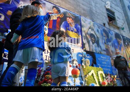 Kleine Mädchen Fans von Neapel, mit der offiziellen Uniform des Teams, mit ihrem Vater, bewundern die Bilder von Diego Armando Maradona, die spanischen Bezirke Stockfoto