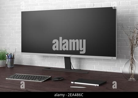 Leeres Breitbild-Display. Arbeitsplatz mit dunklem Holztisch und weißer Ziegelwand. Seitenansicht Stockfoto
