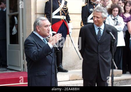 Der scheidende Premierminister Jean-Pierre Raffarin (L) hält seine Rede, während sein Nachfolger Dominique de Villepin am Dienstag, den 31. Mai 2005, auf den Stufen des Büros des Premierministers im Hotel Matignon in Paris, Frankreich, zuhört. Der französische Präsident Jacques Chirac ersetzte Raffarin durch den ehemaligen Innenminister, zwei Tage nachdem die französischen Wähler der Regierung einen strafenden Schlag versetzt hatten, indem sie die neue Verfassung der Europäischen Union ablehnten. Foto von Abd Rabbo-Klein/ABACA. Stockfoto