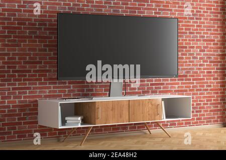 Der Breitbildschirm des Fernsehers stand in der Nähe einer Ziegelwand. Seitenansicht Stockfoto