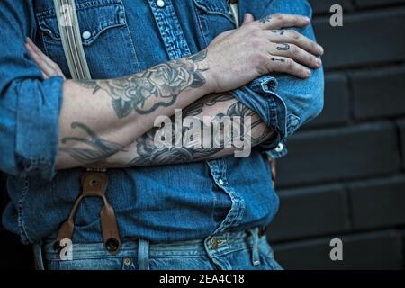 Mann mit Tattoos trägt Jeans mit Strapshaltern Stockfoto