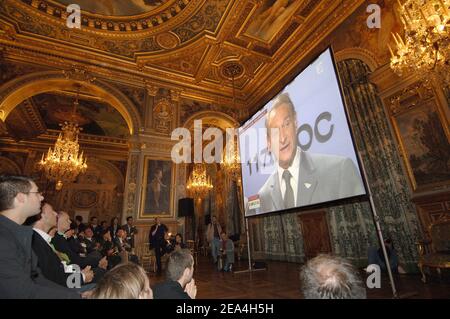 Ein großes Publikum hört im Hotel de Ville von Paris um drei Uhr morgens auf einer Großleinwand live auf T.V, Paris Bürgermeister Bertrand Delanoe hält seine Rede bei der Paris-Stadtpräsentation im Raffles City Convention Center in Singapur am 6. Juli 2005. Das Internationale Olympische Komitee wird später am Tag darüber abstimmen, ob London, Paris, New York, Madrid oder Moskau die Olympischen Spiele 2012 ausrichten werden. Foto von Christophe Guibbaud/Cameleon/ABACAPRESS.COM Stockfoto