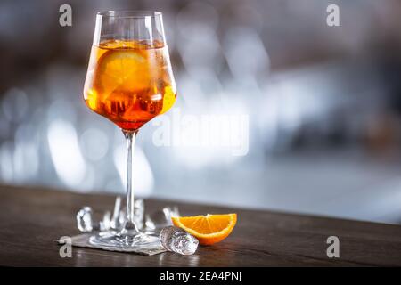 Typisches Sommersekt aperol Spritz serviert in Weinglas mit aperol, Prosecco, Soda und einer Scheibe Orange. Stockfoto