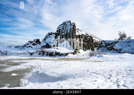 Panska skala - Gesteinsbildung von fünfeckigen und sechseckigen Basaltsäulen. Sieht aus wie riesige Orgelpfeifen. Im Winter von Schnee und Eis bedeckt. Kamenicky Senov, Tschechische Republik. Stockfoto