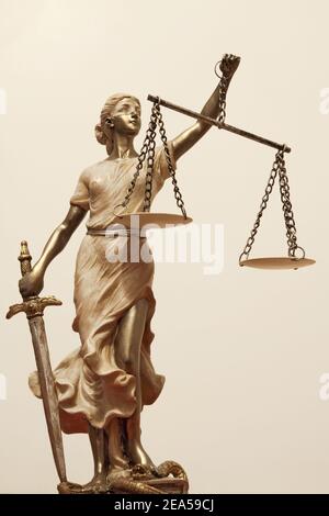 Gerechtigkeit (griechisch: themis, lateinisch: justitia) mit verbundenen Augen mit Waage, Schwert und Geld auf einer Skala. Stockfoto