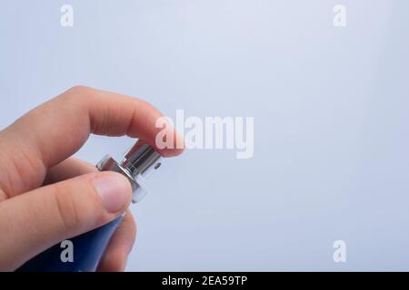 Drücken Sie die Taste, indem Sie die blaue Desinfektionsflasche aufsprühen. Schutz vor Viren, Gesundheitskonzept. Stockfoto