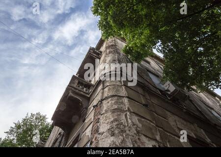 Der abblätternde Putz an der Ecke eines alten Wohngebäudes mit verfallenden Wänden in der Innenstadt von Belgrad, Serbien, muss dringend renoviert werden. Pict Stockfoto