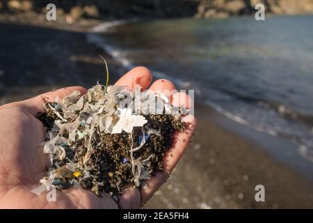 Kleine Kunststoffteile und Mikroplastik am Sandstrand Stockfoto