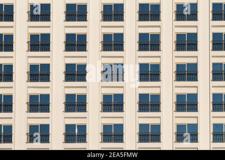 Hotelfassade mit vielen Fenstern auf weißer Wand Stockfoto